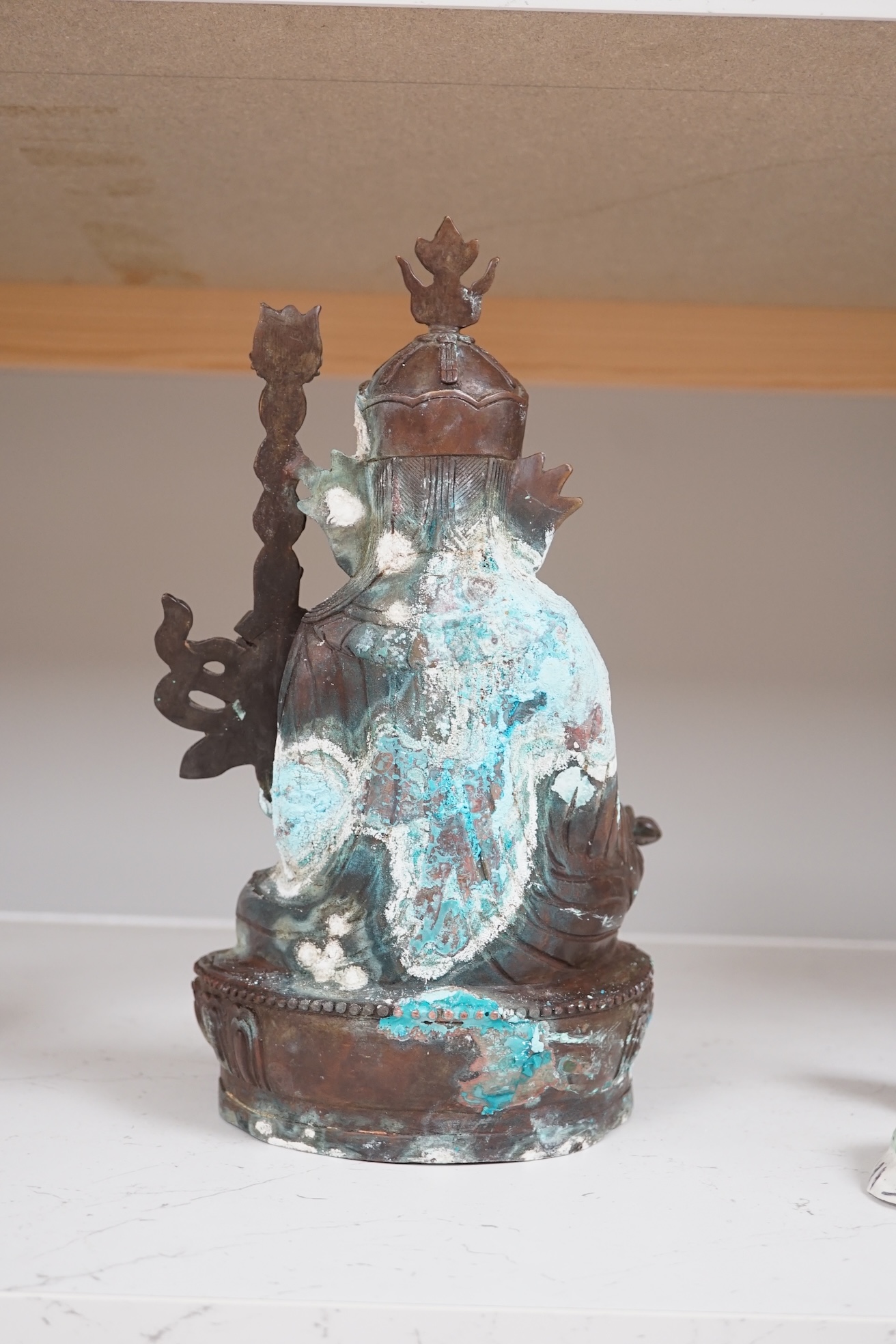 A Tibetan bronze Padmasambhava Buddhist figure, 29.5cm high. Condition - poor to fair.